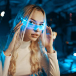 Cute blonde in futuristic fashion style. Neon glasses for a young woman.